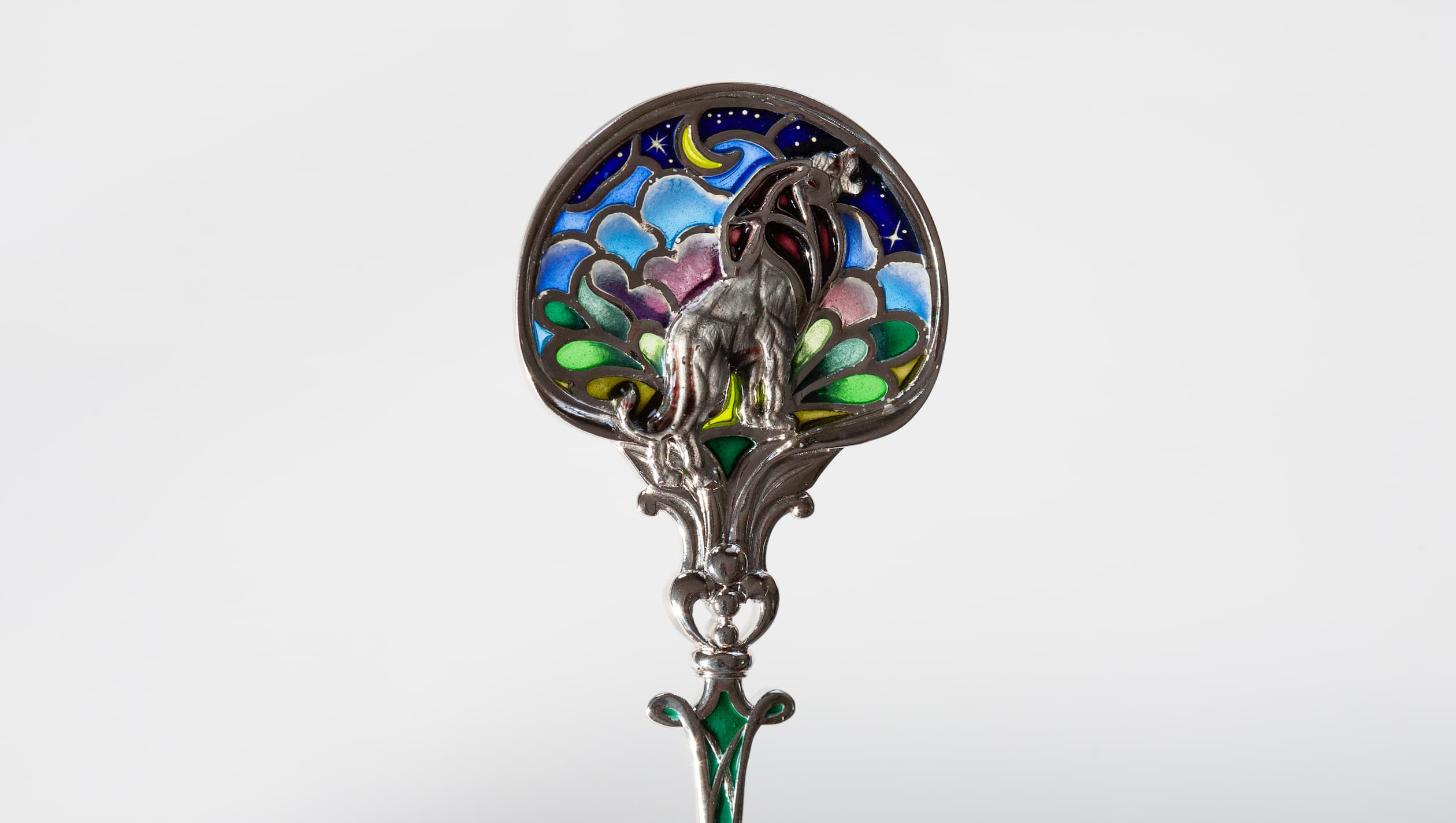 Витражная ложка с серебряным львом при ярком свете Серебряная чайная ложка со львом в технике витражной и перегородчатой эмали, изготовленная мастерской Хризолит. Фото 8.